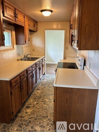 A kitchen with wooden cabinets and a granite counter top.