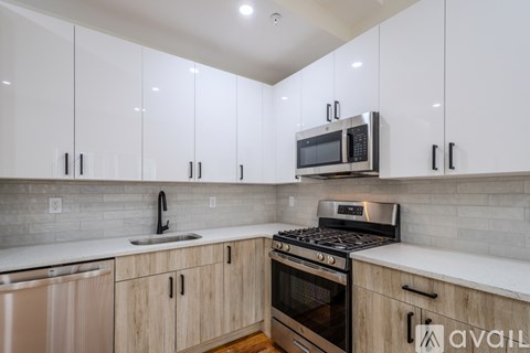 A kitchen with white cabinets and a black stove top oven.