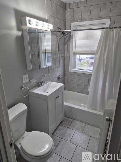 A bathroom with a toilet, sink, and bathtub.