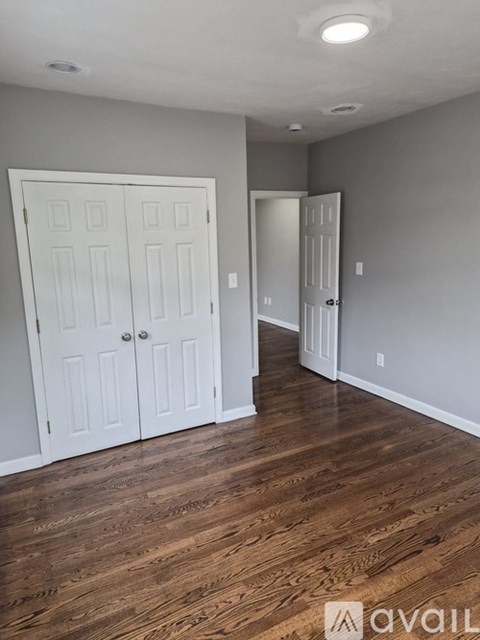 A room with wood floors and two white doors.