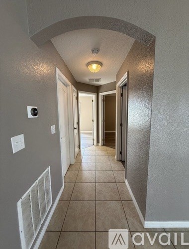 A hallway with a light on the ceiling and a door at the end.