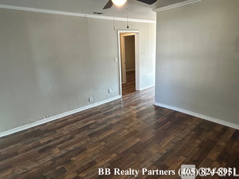 A room with wooden floors and a ceiling fan.