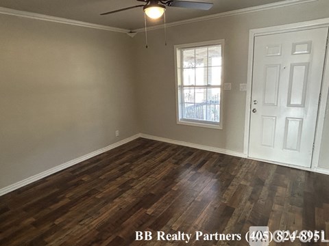 A room with a white door and a window with blinds.