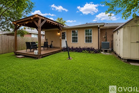 A backyard with a gazebo and a lawn.
