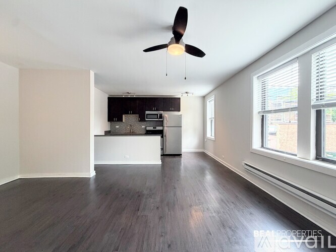 A spacious room with a ceiling fan and wooden flooring.