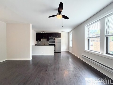 A spacious room with a ceiling fan and wooden flooring.