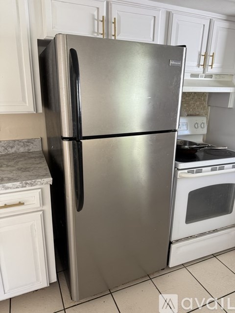 A stainless steel refrigerator stands in a kitchen.