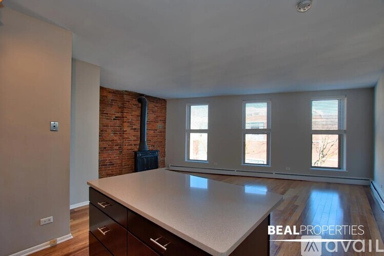 A room with a large countertop and a brick wall with a vent.