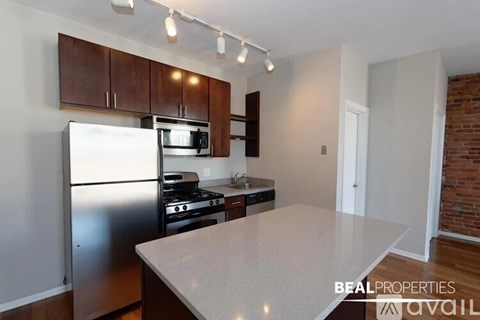 A kitchen with a refrigerator, microwave, oven, and stove.