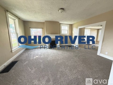 A room with carpeted floor and a logo of Ohio River Properties, LLC on the wall.