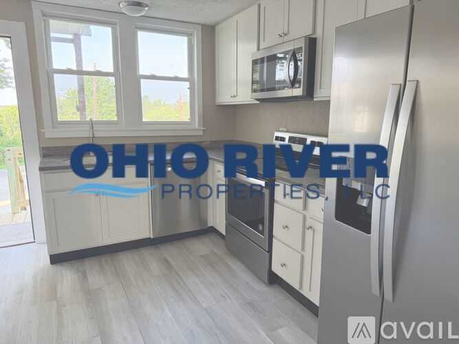 A kitchen with a refrigerator and a sign that says Ohio River Properties.