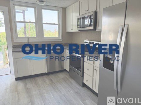 A kitchen with a refrigerator and a sign that says Ohio River Properties.