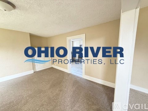 A room with a carpeted floor and a sign that says Ohio River Properties, LLC.