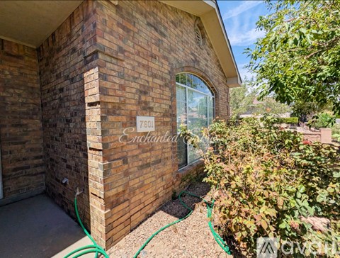 A brick house with a sign that says "Enchanted".