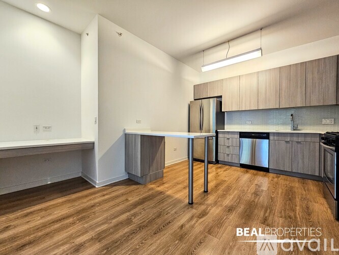 A kitchen with a table and stainless steel appliances.