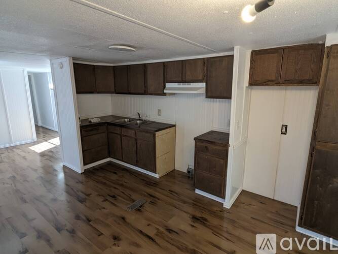 A kitchen with wooden floors and cabinets.