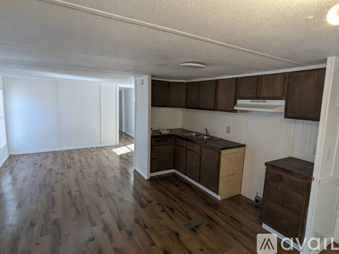 A kitchen with wooden floors and cabinets.