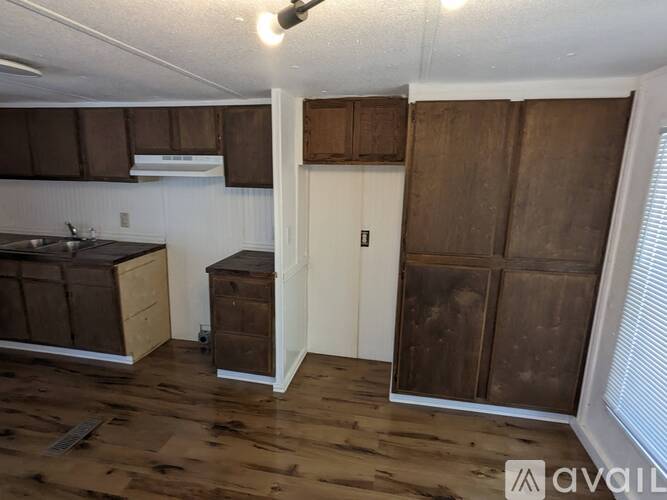 A kitchen with wooden floors and cabinets.