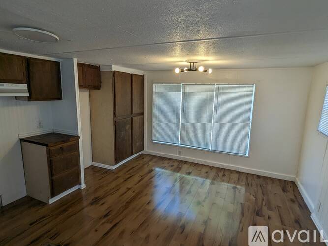 A room with wooden floors and a cabinet is available for rent.