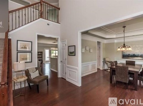 A living room with a brown sofa and a wooden staircase.