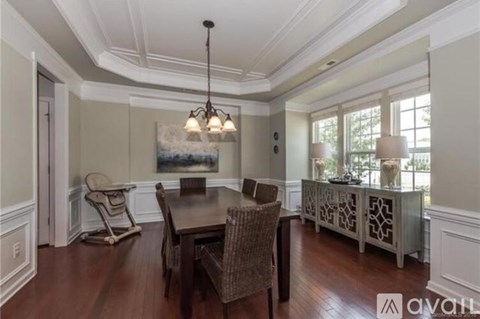 A dining room with a wooden table and chairs.