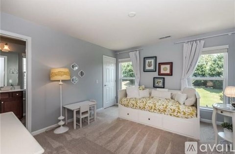 A bedroom with a bed, table, and chairs.