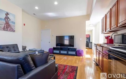 A living room with a black couch and a television.