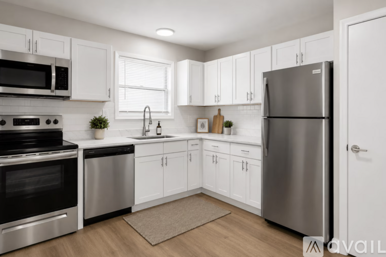 A modern kitchen with white cabinets and stainless steel appliances.