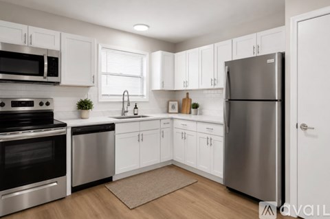 A modern kitchen with white cabinets and stainless steel appliances.