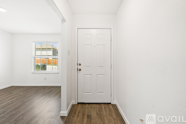 A room with a white door and a window with blinds.