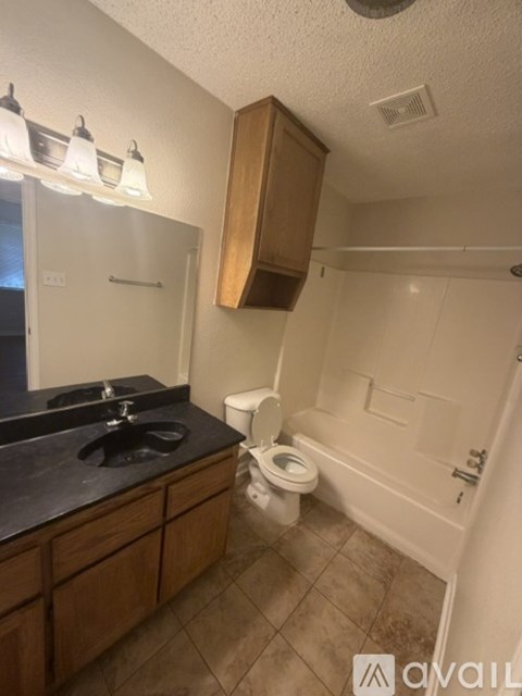 A bathroom with a toilet, sink, and mirror.