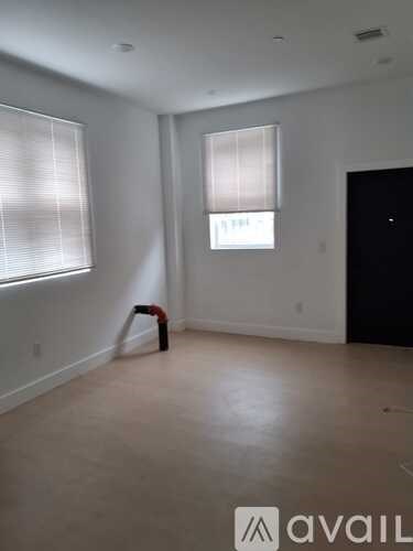 A room with a window and a door is available for rent.