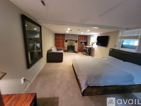 A bedroom with a large bed and a fireplace.