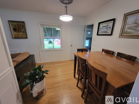 A dining room with a wooden table and chairs.