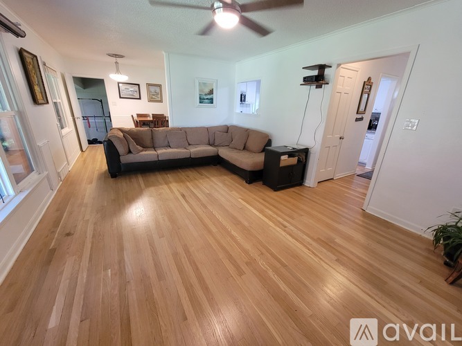 A living room with a couch and a fan.