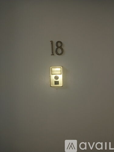 A wall with a number 18 and a light switch.