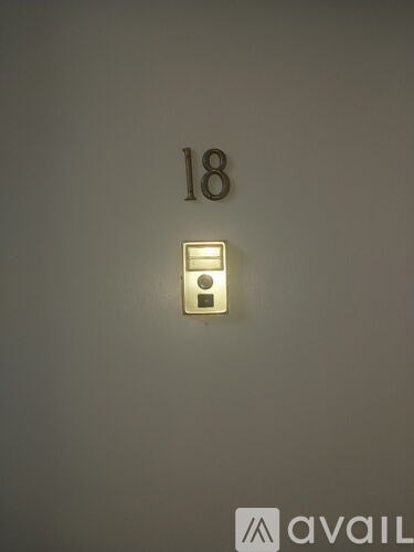 A wall with a number 18 and a light switch.