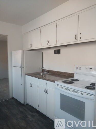 A kitchen with white cabinets and a stove top oven.