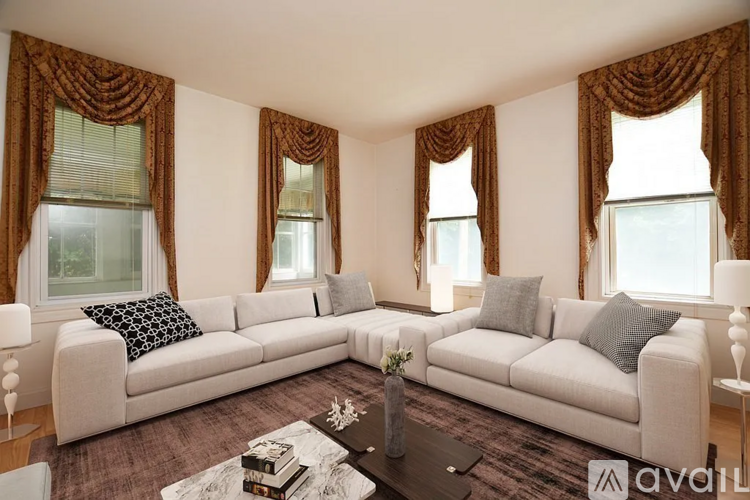 A living room with a white sofa and brown curtains.