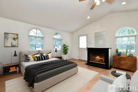 A bedroom with a large bed and a fireplace.