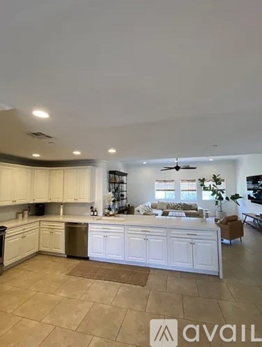 A kitchen with white cabinets and a fan on the ceiling.