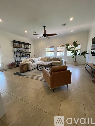 A living room with a brown leather chair and a white couch.
