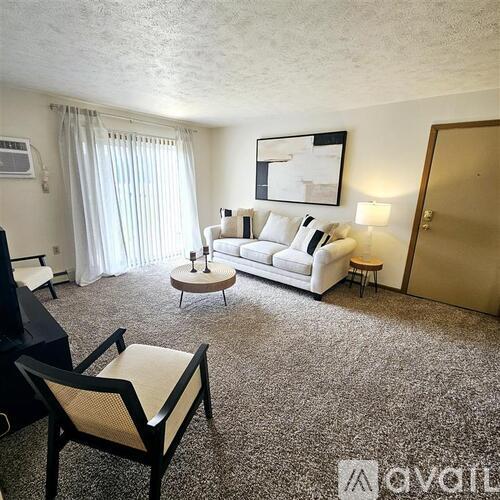 A living room with a white sofa, a coffee table, and a television.