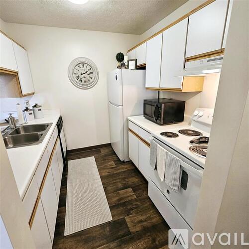 A kitchen with white cabinets and a black microwave.