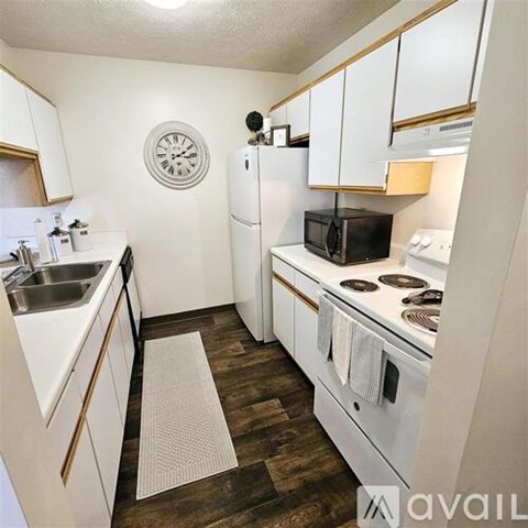 A kitchen with white cabinets and a black microwave.