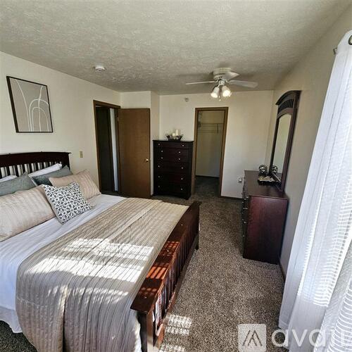 A bedroom with a bed, dresser, and mirror.