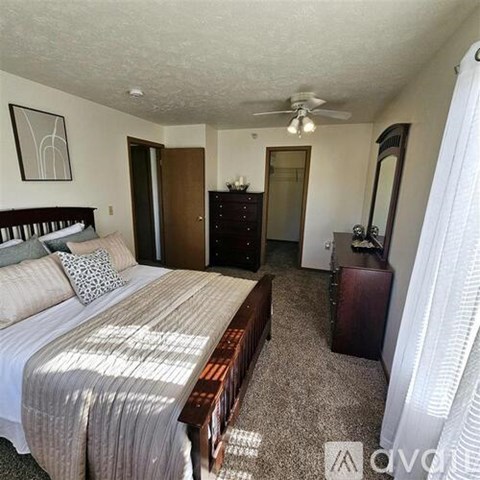 A bedroom with a bed, dresser, and mirror.