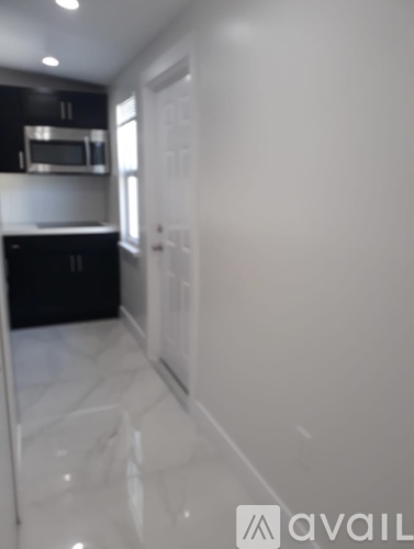 A kitchen with black cabinets and a white floor.