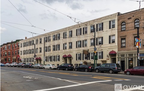 A row of buildings with cars parked in front.