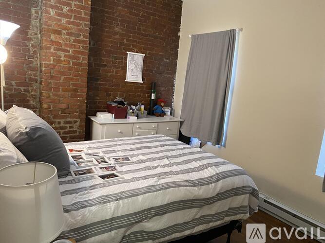 A bedroom with a bed, nightstand, and a lamp.